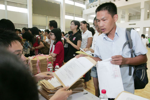 在報(bào)到現(xiàn)場，蔡偉從工作人員手中接過新生報(bào)到材料。  劉暢/攝 